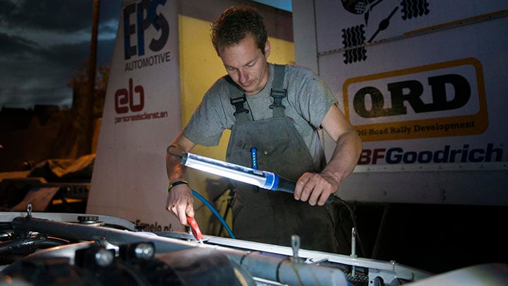Uma luz de trabalho LED melhora a visão de um homem que repara um automóvel