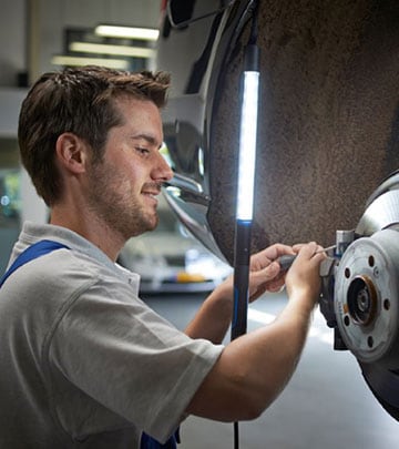 Uma luz de trabalho LED melhora a visão de um homem que repara um automóvel