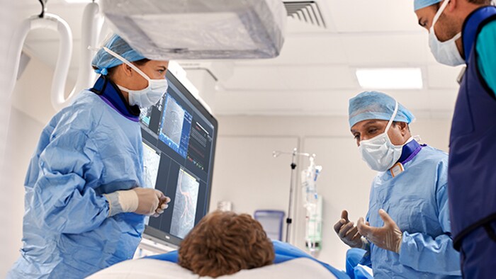 Cardiologistas intervencionistas olhando imagens clínicas